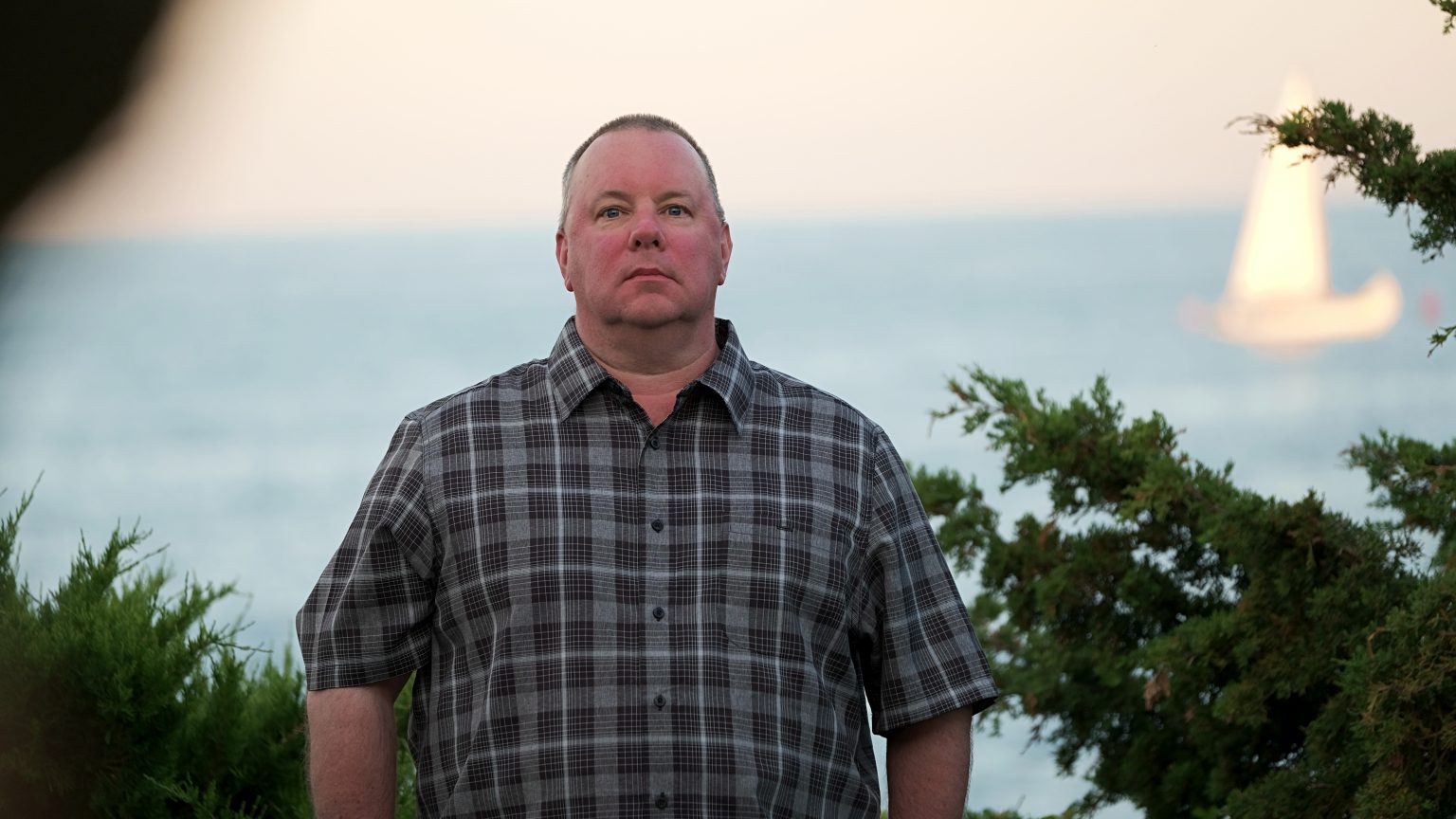 Paul Hackett, Christian transformation coach, standing outdoors by the ocean at sunset